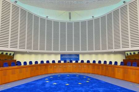 Courtroom with empty chairs and bright blue carpet with EU flag