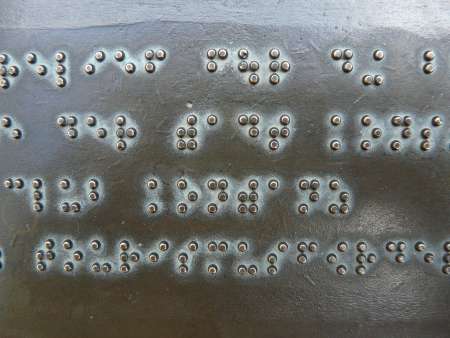 Close-up of the bumps on a bronze Braille printing plate.