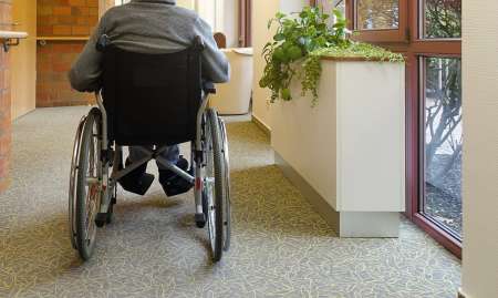 Elderly man in wheelchair in nursing home.